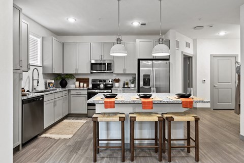 an open kitchen with a large island with three stools